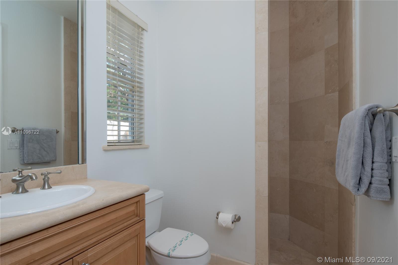 4900 Pine Tree Drive Miami Beach, FL 33140 - Photo 29 of 64 a bathroom with a granite countertop sink toilet and mirror
