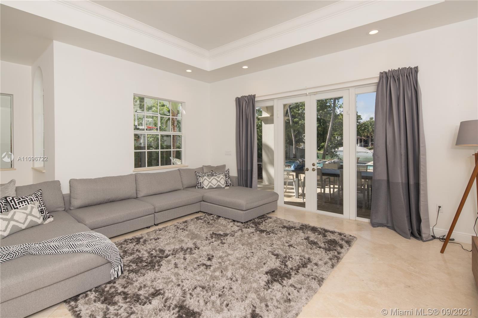 4900 Pine Tree Drive Miami Beach, FL 33140 - Photo 33 of 64 a living room with furniture and a large window