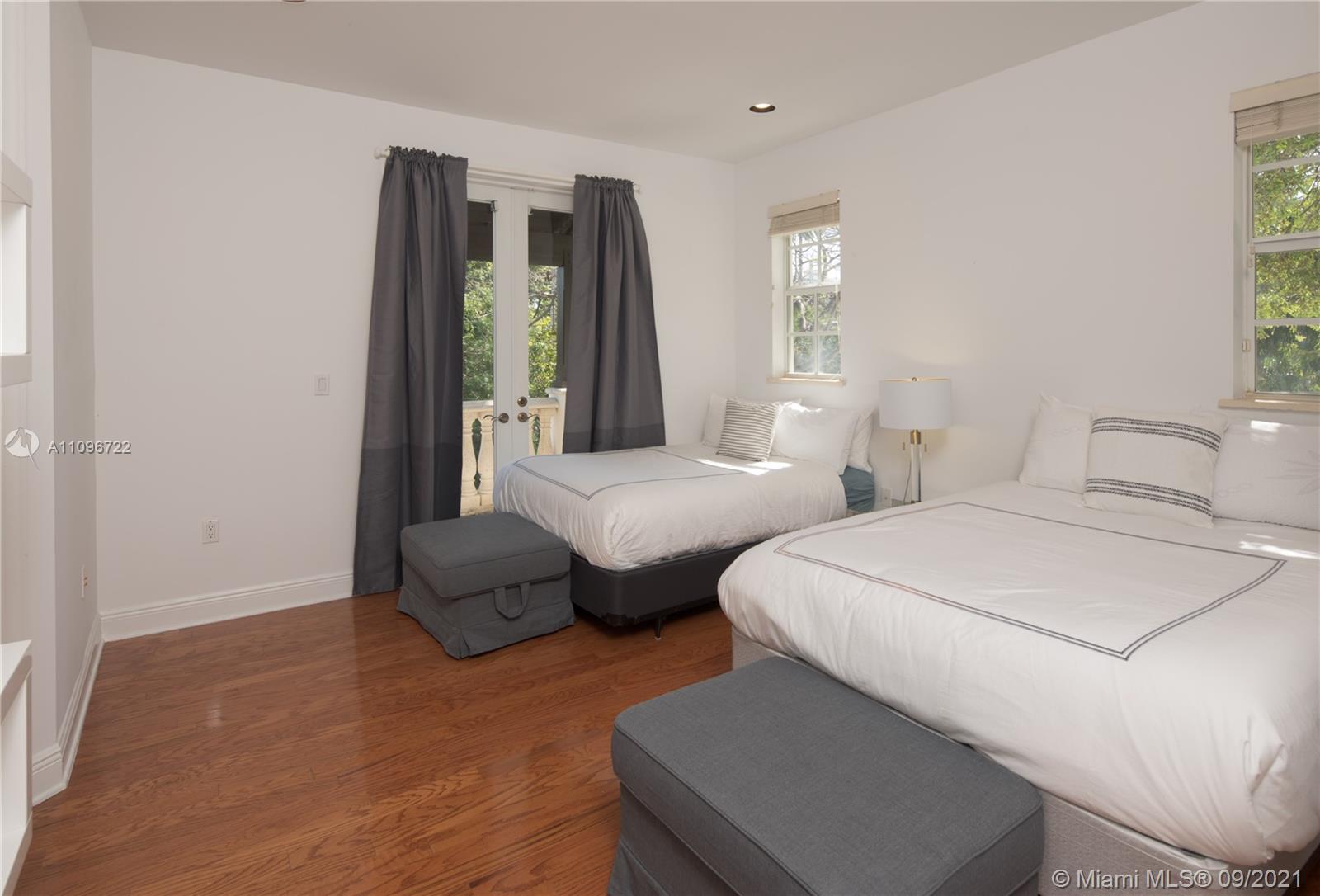 4900 Pine Tree Drive Miami Beach, FL 33140 - Photo 39 of 64 a bedroom with two beds and a large window