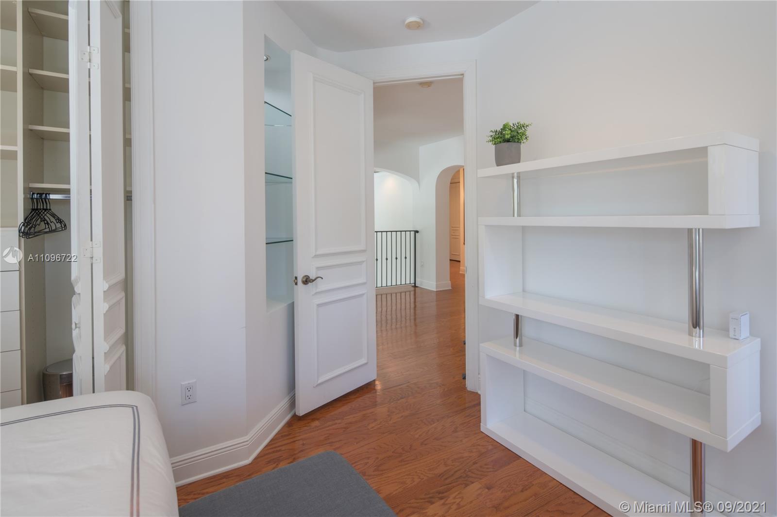 4900 Pine Tree Drive Miami Beach, FL 33140 - Photo 43 of 64 a view of walk in closet with empty racks