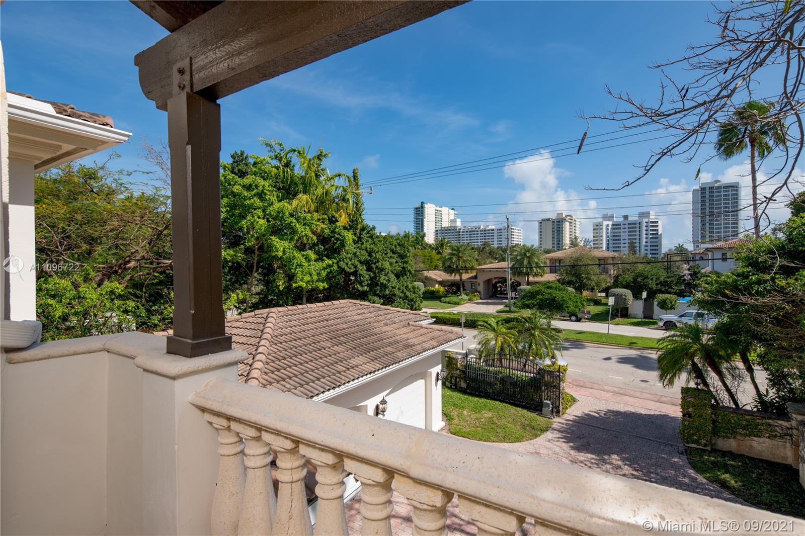 4900 Pine Tree Drive Miami Beach, FL 33140 - Photo 45 of 64 a view of a patio with table and chairs potted plants with wooden floor and fence
