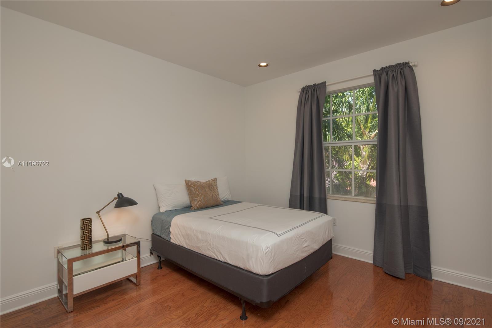 4900 Pine Tree Drive Miami Beach, FL 33140 - Photo 49 of 64 a bedroom with a bed and a window