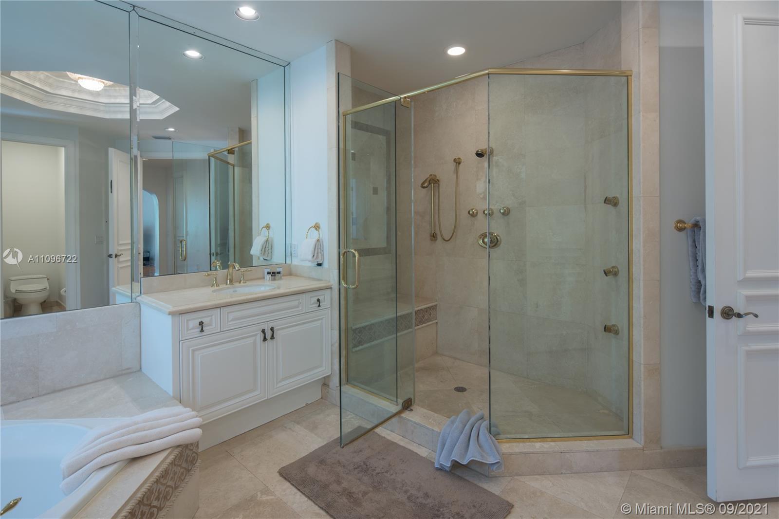 4900 Pine Tree Drive Miami Beach, FL 33140 - Photo 55 of 64 a bathroom with a shower a sink and a mirror