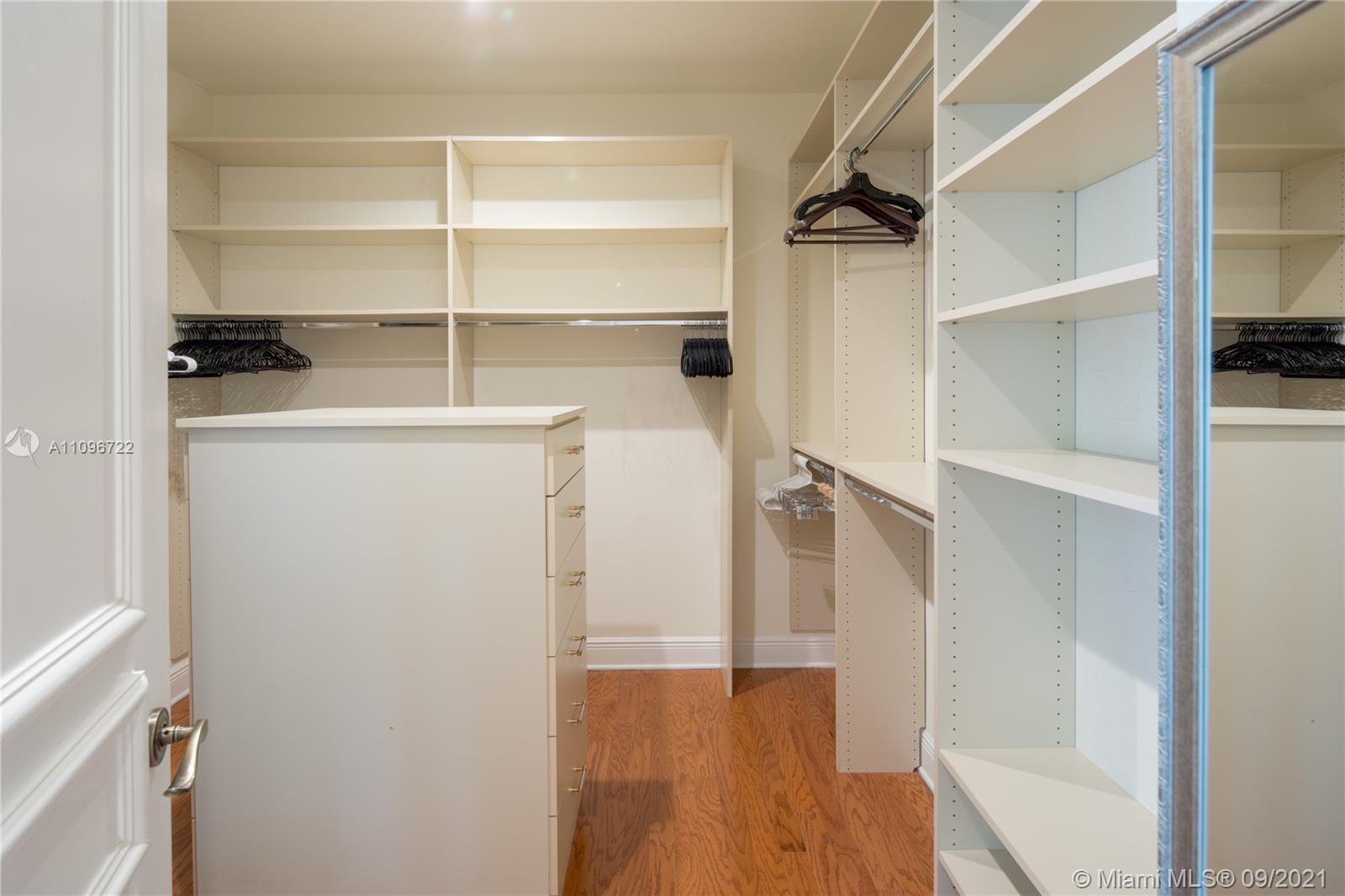 4900 Pine Tree Drive Miami Beach, FL 33140 - Photo 56 of 64 a view of walk in closet with empty racks
