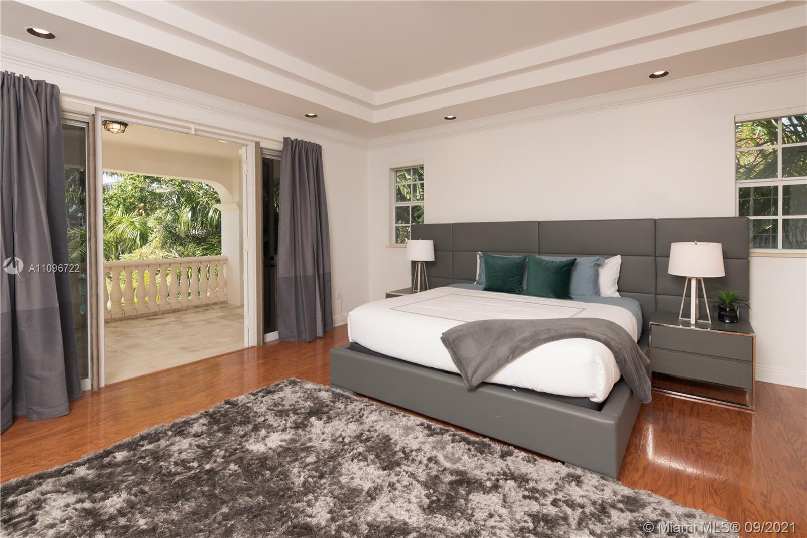 4900 Pine Tree Drive Miami Beach, FL 33140 - Photo 60 of 64 a bedroom with a large bed and a window