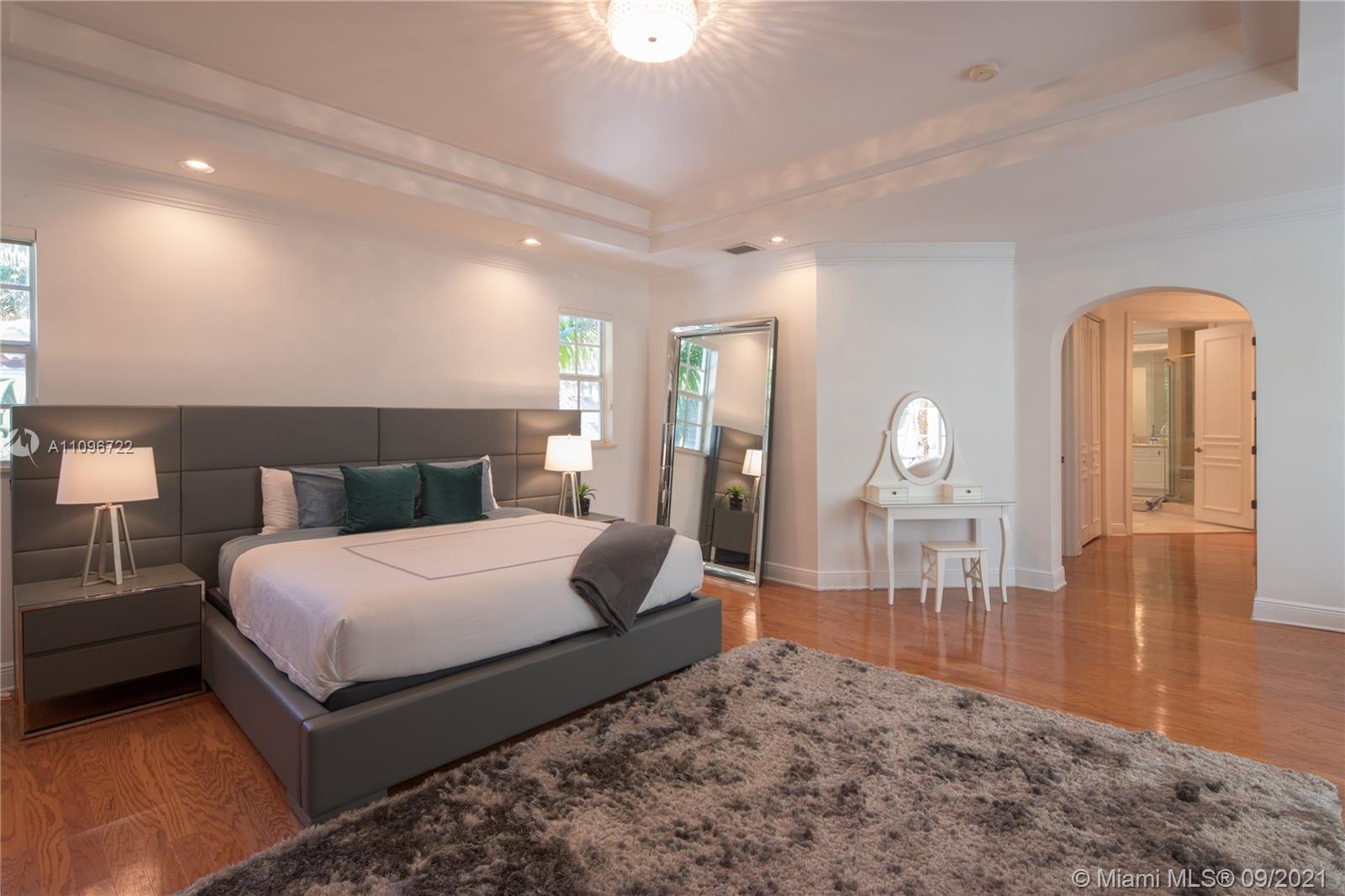 4900 Pine Tree Drive Miami Beach, FL 33140 - Photo 61 of 64 a bedroom with a bed a mirror and night stand