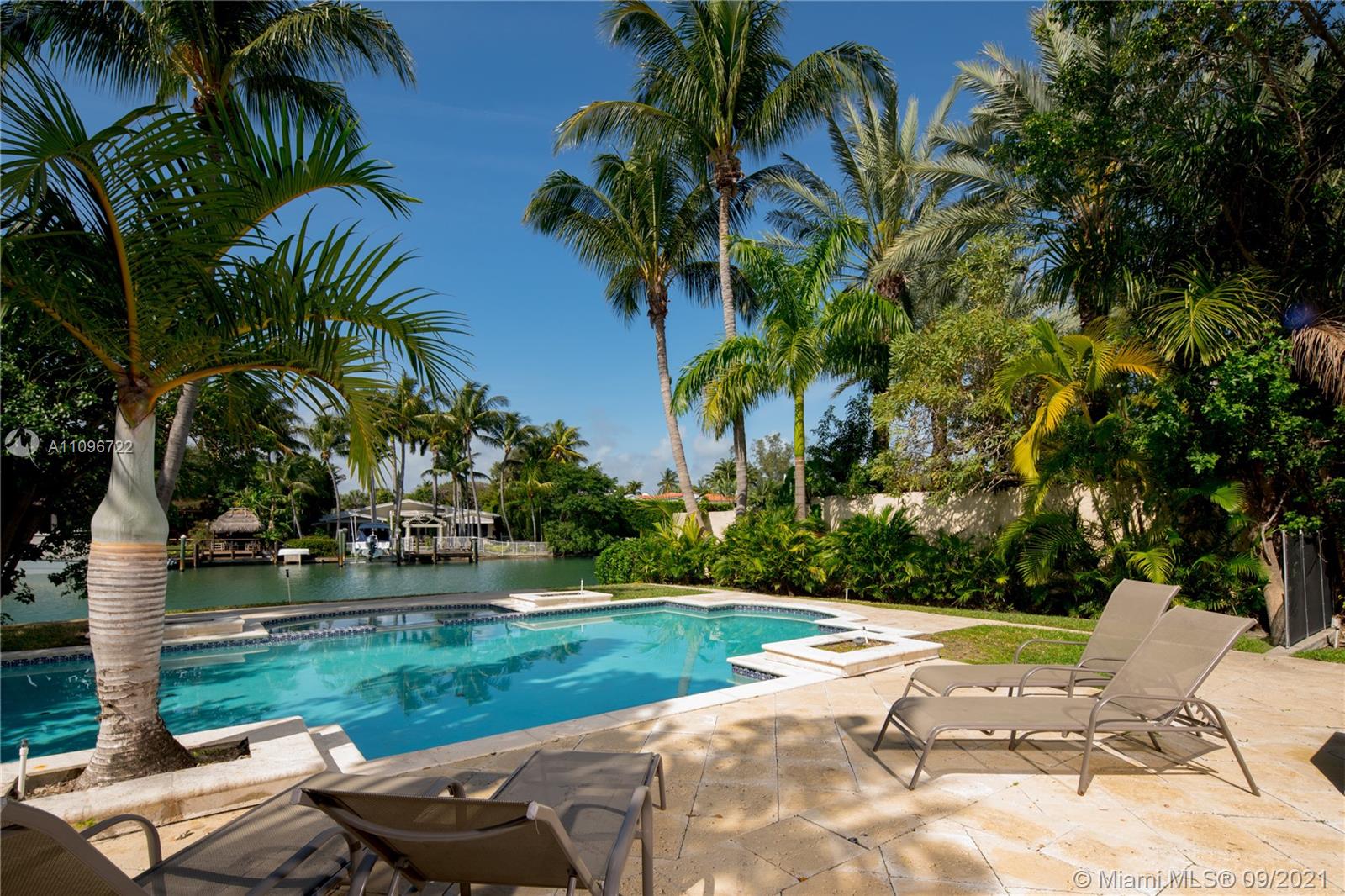 4900 Pine Tree Drive Miami Beach, FL 33140 - Photo 9 of 64 a view of a backyard with a garden and swimming pool