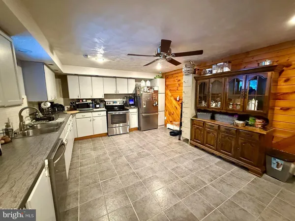 a large kitchen with stainless steel appliances and a stove top oven