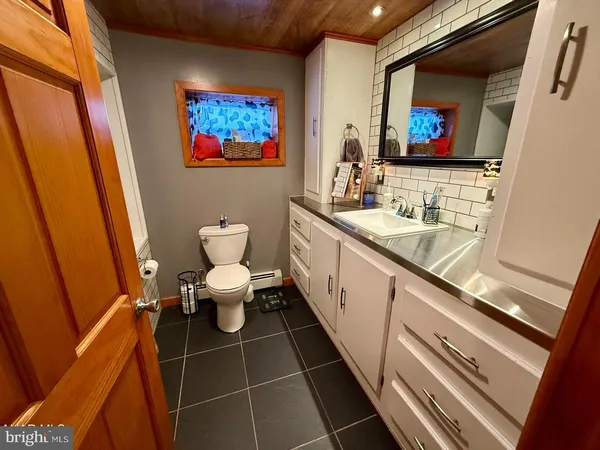 a bathroom with a toilet a sink and mirror