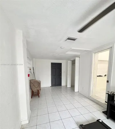 an empty room with cabinet and mirror