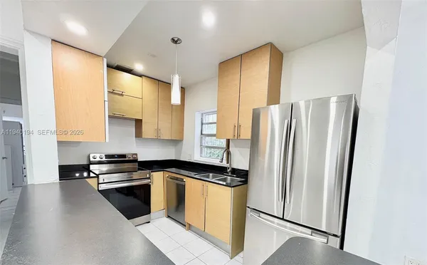 a kitchen with stainless steel appliances a refrigerator a sink a stove a microwave a counter space and cabinets