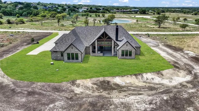 a aerial view of a house with a yard and lake view