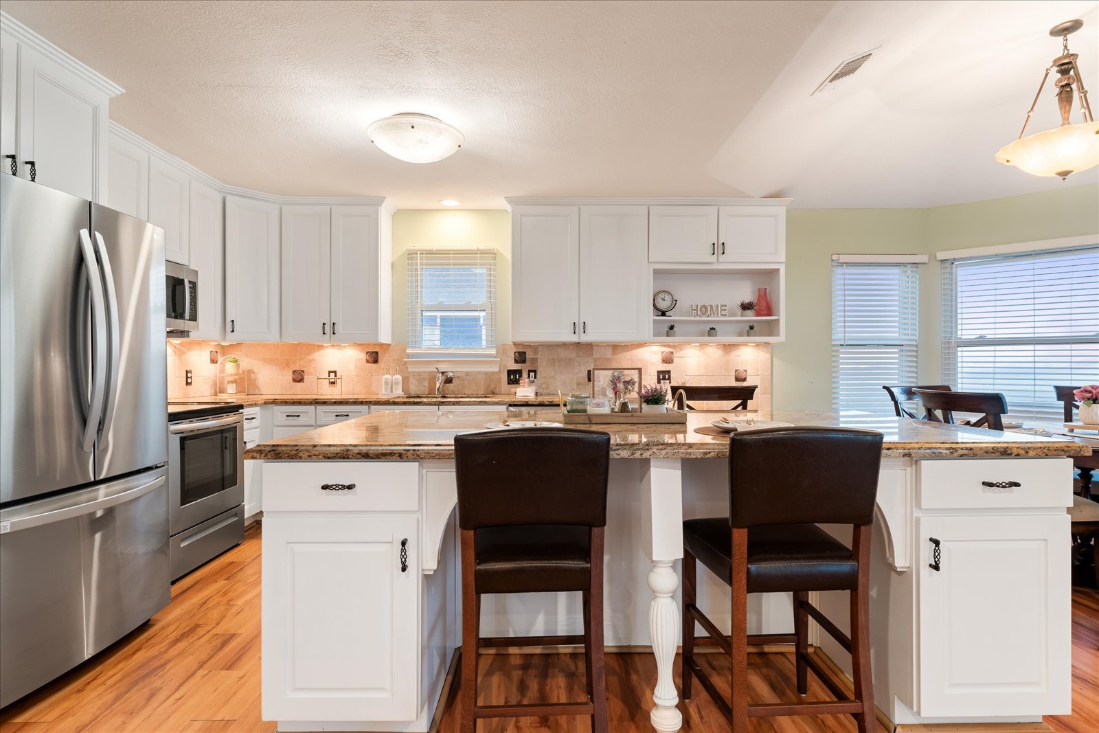 24043 Termini-San Luis Pass Road Galveston, TX 77554 - Photo 10 of 26 a kitchen with granite countertop white cabinets and stainless steel appliances