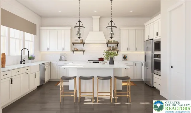 a kitchen with stainless steel appliances kitchen island granite countertop a refrigerator a stove and white cabinets with wooden floor