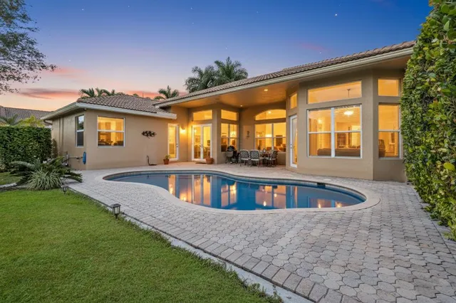 a front view of house with yard and trees in the background
