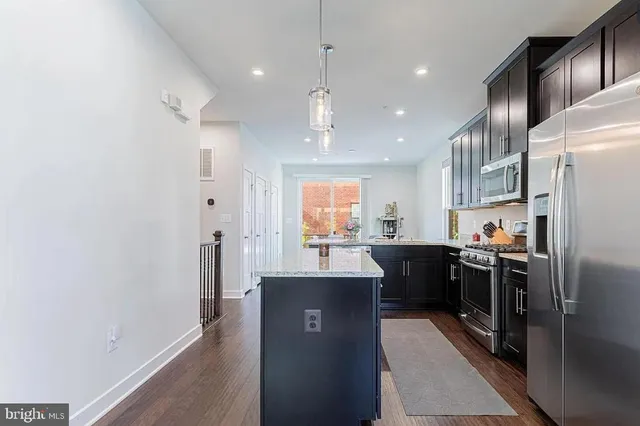 a kitchen with kitchen island a sink stainless steel appliances and cabinets
