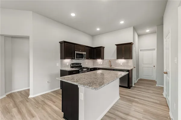 a large kitchen with a center island and stainless steel appliances