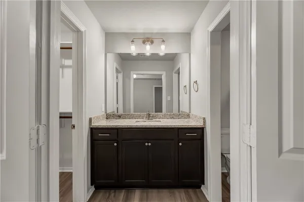 a bathroom with a granite countertop sink a mirror and a vanity