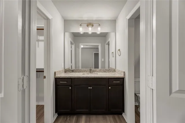a bathroom with a granite countertop sink a mirror and a vanity