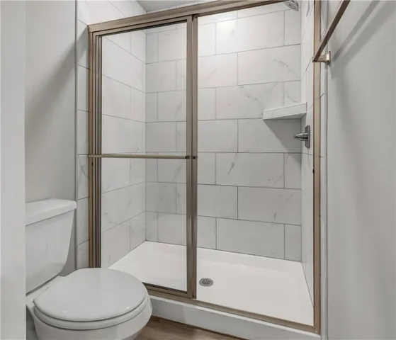 a white toilet sitting next to a bathtub