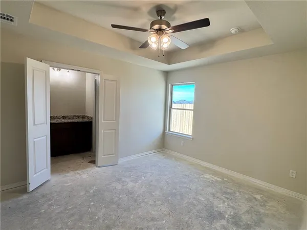 an empty room with a ceiling fan and a window