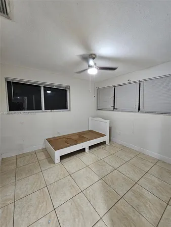 a bedroom with a bed and a ceiling fan