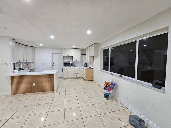 a kitchen with stainless steel appliances granite countertop a stove a sink and white cabinets