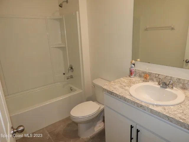a bathroom with a granite countertop sink a toilet and bathtub