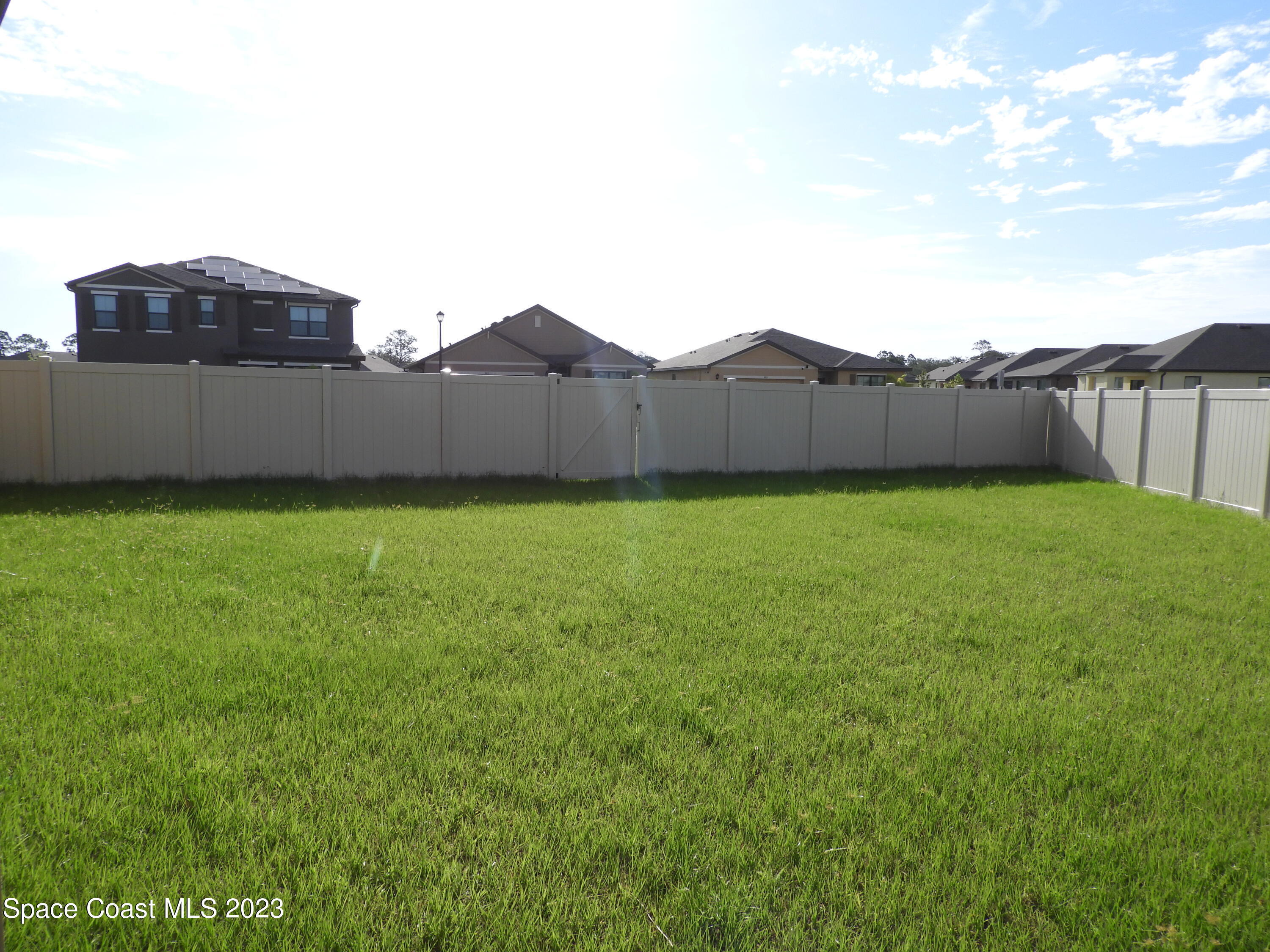 3782 Coachman Lane Southeast Palm Bay, FL 32909 - Photo 31 of 31 a view of a house with a yard and a large tree