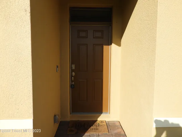 a view of a hallway with wooden floor and a bathroom