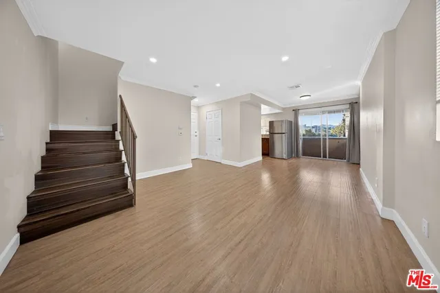 a view of a hallway with wooden floors and stairs