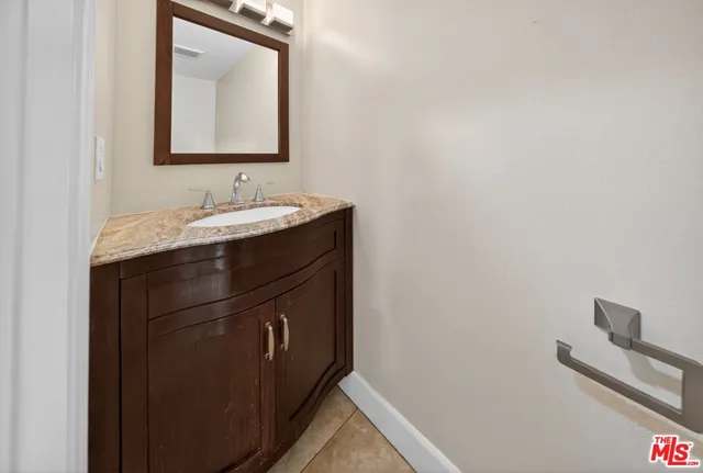 a bathroom with a granite countertop sink and a mirror