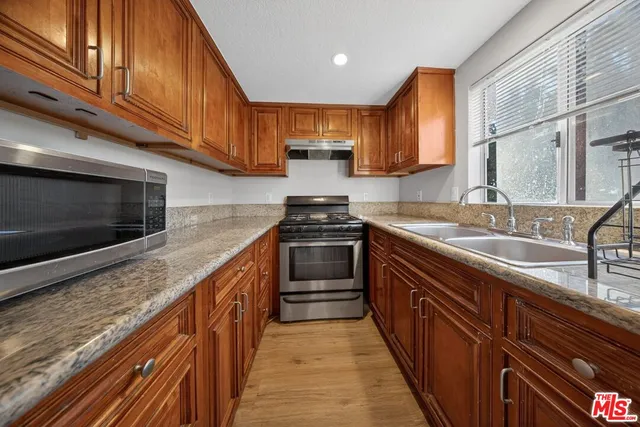 a kitchen with stainless steel appliances granite countertop wooden cabinets a sink and dishwasher