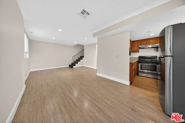 a view of a kitchen with a sink a refrigerator and wooden floor