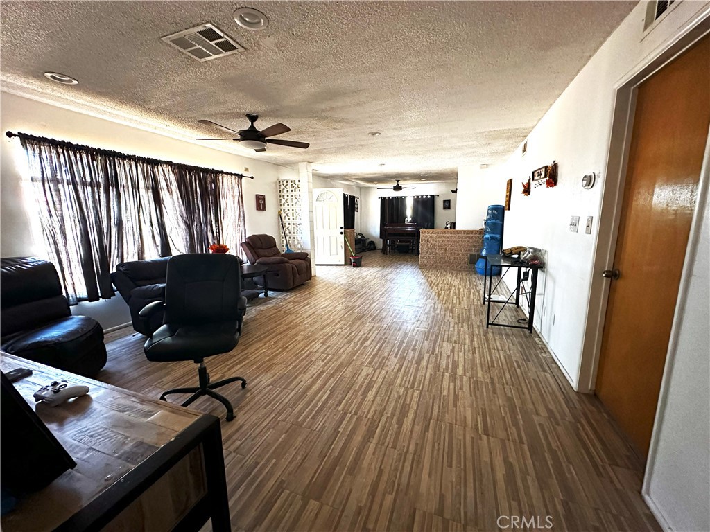 14822 Rodeo Drive Victorville, CA 92395 - Photo 2 of 8 a living room with furniture and a wooden floor