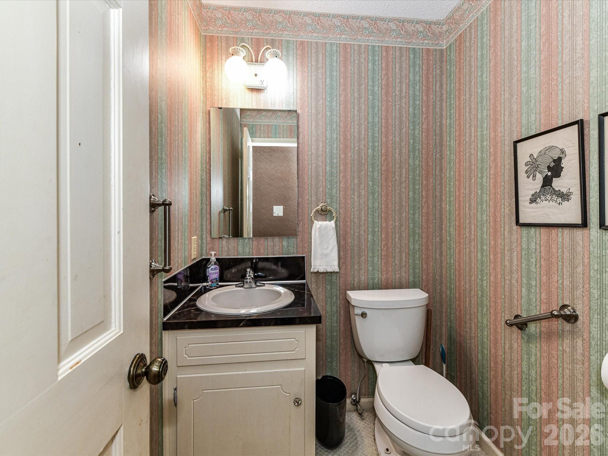 127 Todd Circle Wingate, NC 28174 - Photo 16 of 36 a bathroom with a granite countertop toilet a sink and a mirror