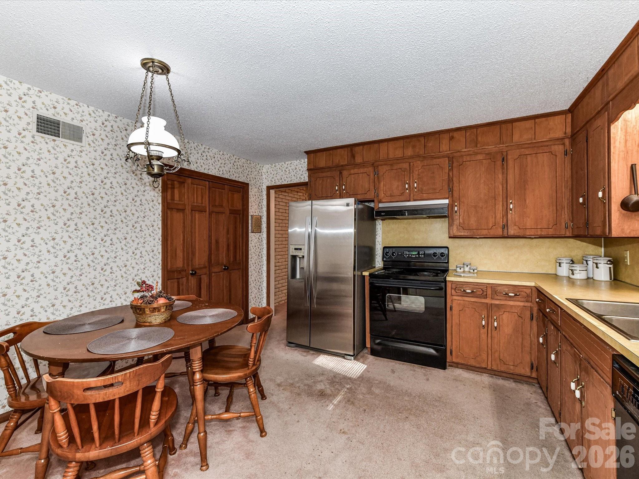 127 Todd Circle Wingate, NC 28174 - Photo 9 of 36 a kitchen with stainless steel appliances granite countertop a stove refrigerator a sink dishwasher a dining table and chairs with wooden floor