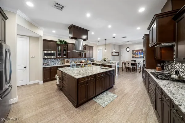 a kitchen with stainless steel appliances granite countertop a sink stove and refrigerator