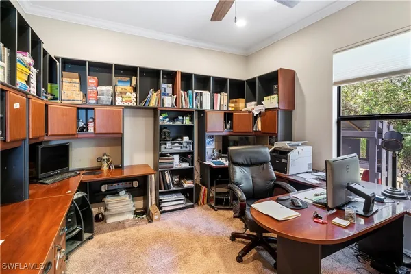 a view of a workspace with furniture and a window