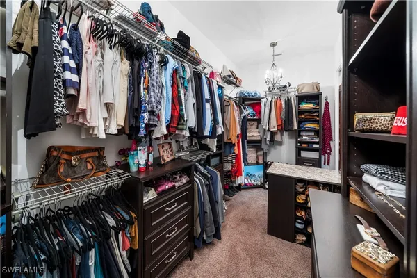 a view of walk in closet with clothes