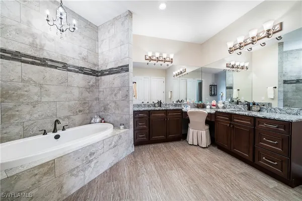 a large bathroom with a double vanity sink a mirror and a bathtub