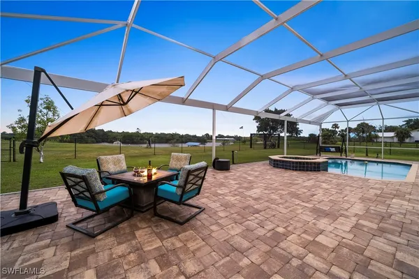 a view of a patio with table and chairs under an umbrella