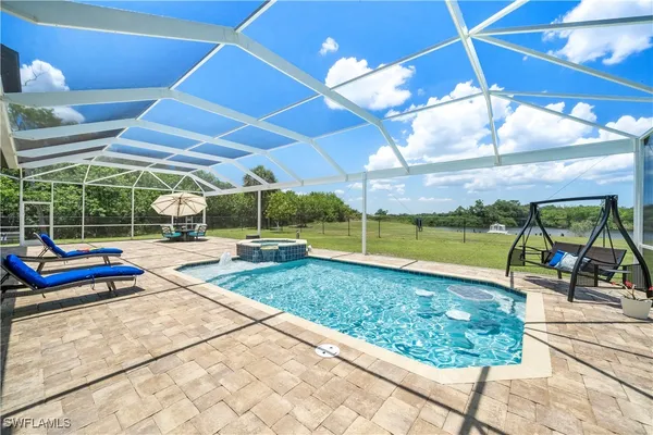 a view of a backyard with table and chairs under an umbrella