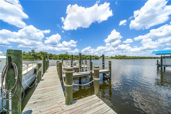 a view of a lake with couches chairs and wooden floor