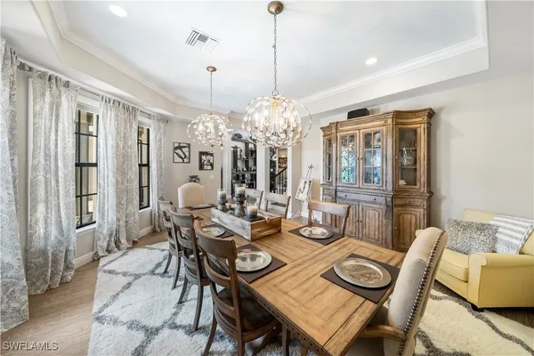 a view of a dining room with furniture a chandelier and wooden floor