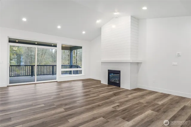 a view of empty room with wooden floor and fireplace
