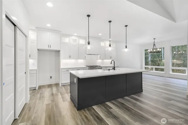 a view of kitchen with stainless steel appliances granite countertop cabinets and wooden floor