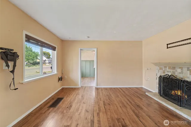 a view of a livingroom with wooden floor and a fireplace
