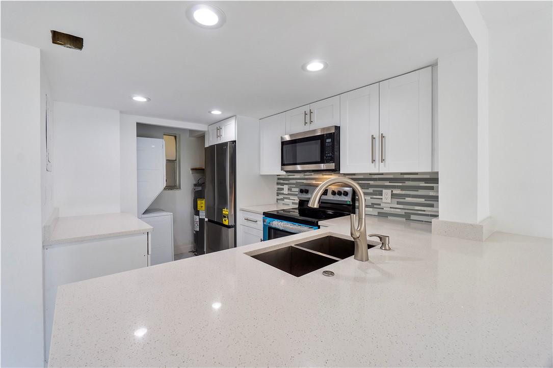 a kitchen with stainless steel appliances a refrigerator sink and microwave