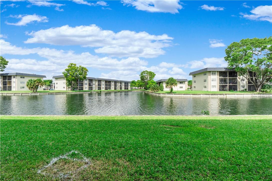 8025 South Colony Circle, Unit 106 Tamarac, FL 33321 - Photo 12 of 14 a view of a lake with a house in the background